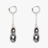 Beautiful handmade sterling silver earrings with dark grey almost black (Kuro) crystals. The crystals are dangling on a sterling silver chain attached to one cm small hoops. The small hoops are easy to open and close due to the leverage. You don’t have to look and poke for the hole. Just pull them open, click and go. The small hoops fit perfectly in your ear.  The unique sterling casts of the crystals are designed with a goldsmith. Making this our own jewelry design, beautifully lasered with our name on the side.